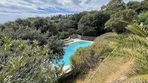 A pool surrounded by dense greenery and a wooden fence. - Villa "terre D'azur" Avec vue mer , Piscine, Jardin Clos, Rénovée (La Croix-Valmer)