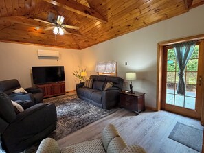 A living room with a television, sofas, a rug, and a wooden ceiling. - Chucle Homestead - Charming 3 bdrm, 2 bath ranch home (Maryland)