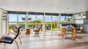 En rummelig opholdsstue med en stor skydedør, der fører ud til en balkon med en dejlig udsigt.