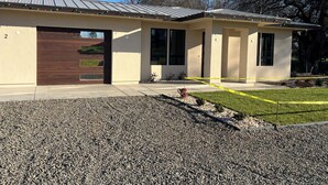 Ein modernes Haus mit Garage, Veranda und gepflegtem Rasen.
