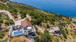A modern villa with a swimming pool, located on a hillside overlooking a large body of water. - Pet friendly home in Stanici (Stanici)