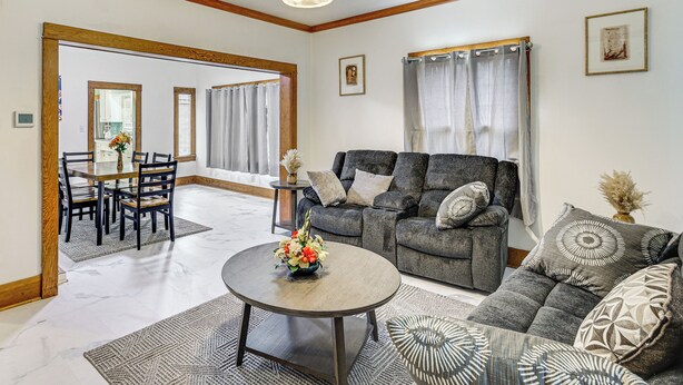 A living room with a sofa, coffee table, and dining area with chairs and a table. - Walk to Eats & Events! Downtown Puyallup Home (Puyallup)