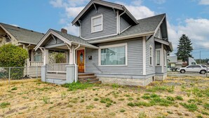 A two-story house with a front porch, a garage, and a driveway. - Walk to Eats & Events! Downtown Puyallup Home (Puyallup)