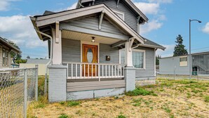 A residential house with a front porch, a wooden door, and a small fenced yard. - Walk to Eats & Events! Downtown Puyallup Home (Puyallup)