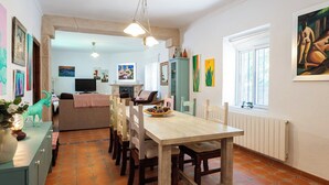 A dining area with a wooden table and chairs, a buffet table with pinecones, and a kitchen in the background. - Alojamiento rural Aloe Pozo Alcón by Ruralidays (Jaén)