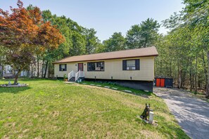 A single-story house with a front porch, a small yard, and a pathway leading to the house. - 'A Time to Remember' Home in Tobyhanna w/ hot tub (Tobyhanna)
