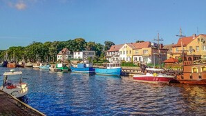 A harbor with several boats docked, surrounded by residential buildings with red roofs. - 2 bedroom gorgeous home in Darlowo (Darlowo)