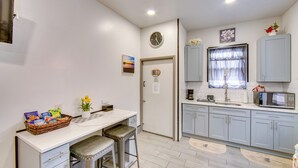 A compact kitchen with a white countertop, two bar stools, a microwave, and a sink. - < 2 Mi to Downtown & Capitol: Harrisburg Hideaway (Harrisburg)