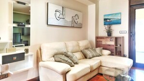 A living room with a sectional sofa, a glass coffee table, a painting, and a potted plant. - Desconectaengalicia Townhouse Vichona 2.5 km from the center of Sanxenxo (Forxán)