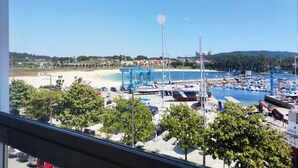 Una marina con barcos, una playa y un cielo despejado.