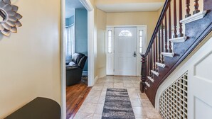 A hallway with a wooden staircase, a door with a window, and a black and white rug. - Pet-Friendly Penn Yan Home: Wineries, Parks, Lakes (Penn Yan)