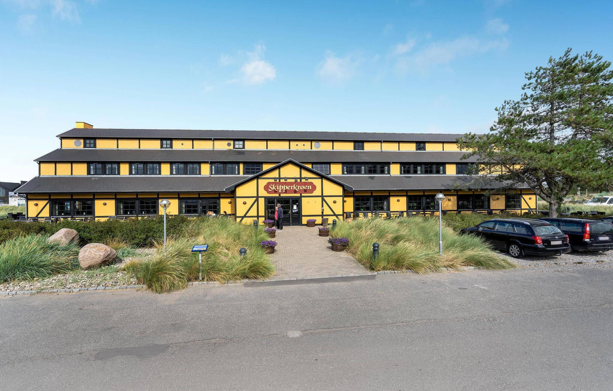 A yellow building with a sign reading "Skipperkroen" at the entrance.