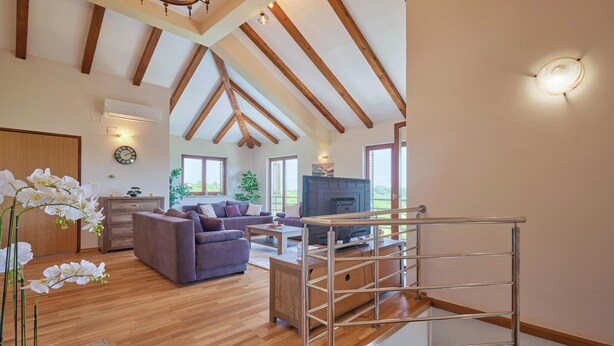 A spacious living room with wooden floors, a sofa set, a fireplace, and a staircase with metal railings. - 2 bedroom lovely home in Kladje (Kladje)