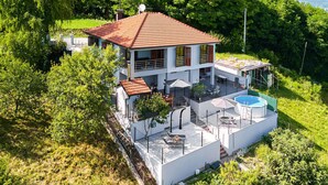 A two-story house with a red-tiled roof, a swimming pool, and a patio area with outdoor furniture. - 2 bedroom lovely home in Kladje (Kladje)