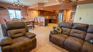 A spacious living room with leather sofas and a dining area.