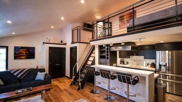 Un apartamento moderno estilo loft con cocina, comedor y sala de estar.