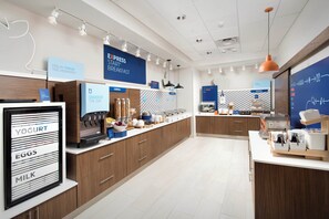 A modern breakfast bar with labeled dispensers for yogurt, eggs, and milk. - Holiday Inn Express and Suites Atlanta South Stockbridge by IHG (Stockbridge)