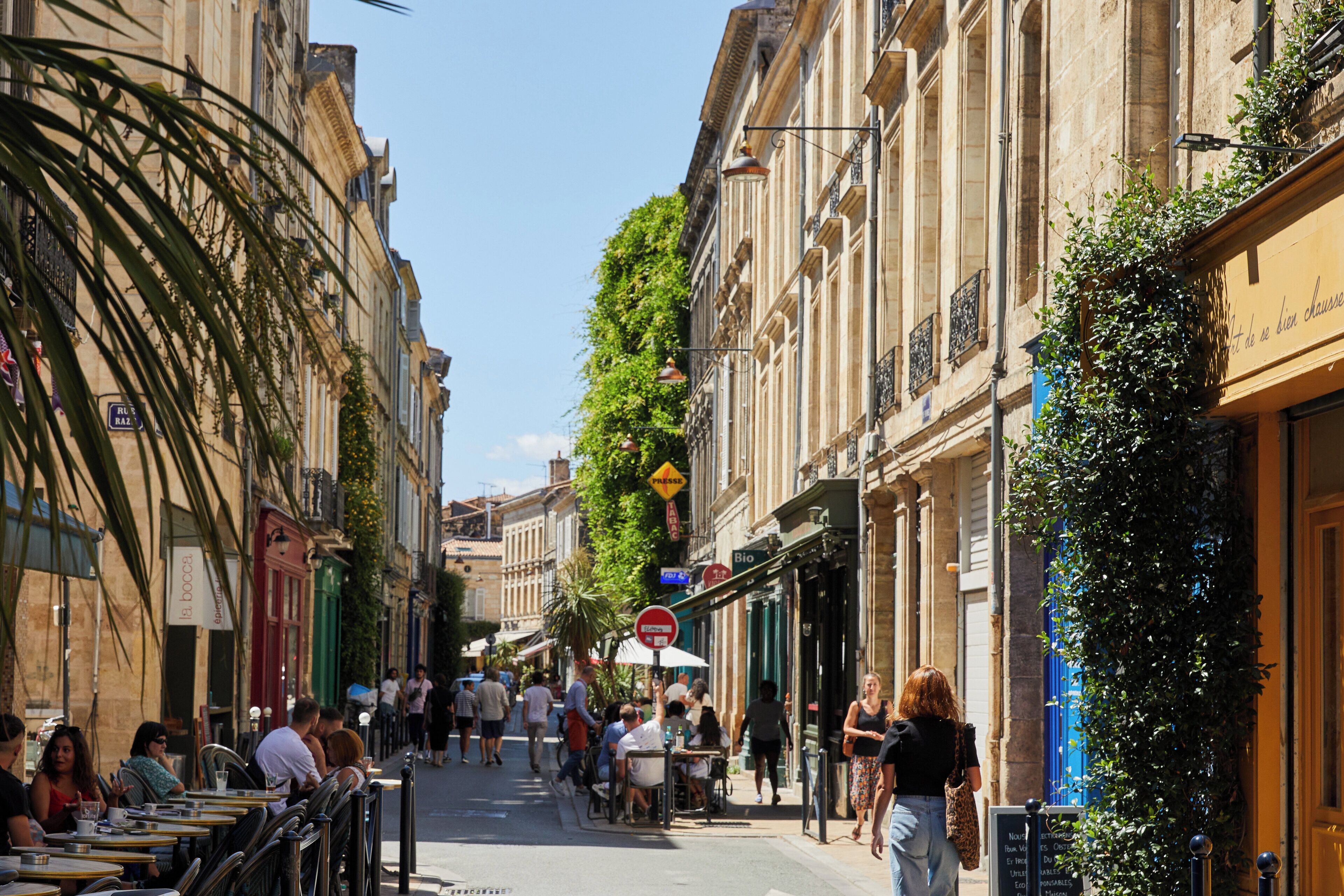 A street with outdoor seating, cafes, and shops.
