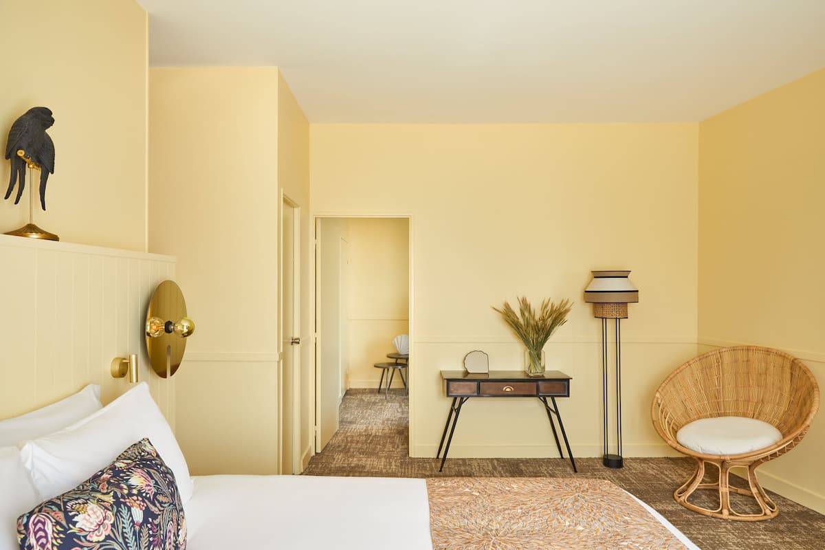 Ein Hotelzimmer mit Bett, Schreibtisch, Stuhl und Lampe.