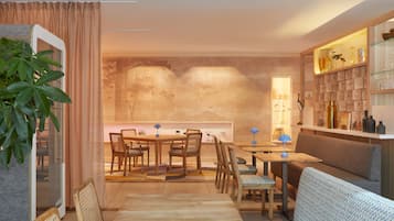 A modern living room with a dining area, featuring a sofa, a coffee table, and a dining table with chairs.