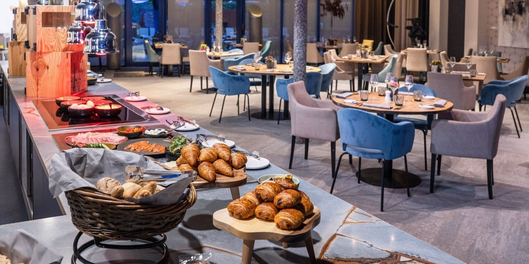 A buffet setup with various food items and a seating area with chairs and tables.
