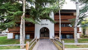 Un edificio llamado Gavilon con una entrada central, fachada de madera y un camino de hormigón que lleva a la puerta.