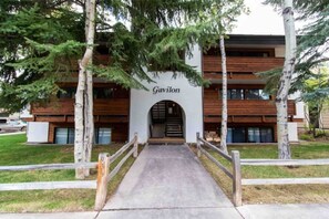 A building named Gavilon with a central entrance, wooden facade, and a concrete pathway leading to the door. - Aspen Downtown with Patio, Fireplace, Parking, W/D (Aspen)