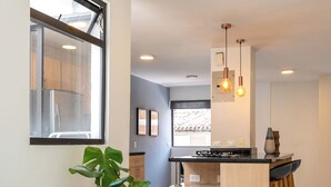 A modern kitchen with a central island, pendant lighting, and potted plants. - Stylish 2BR unit in the Best Scene in Medellin next to Poblado Park (Medellín)