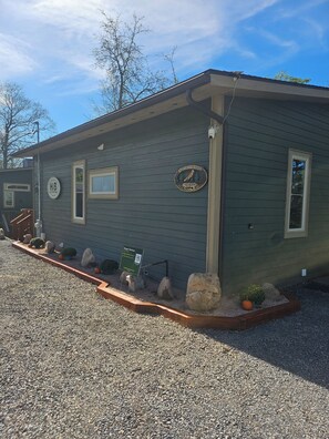 A small, single-story building with a dark exterior, a visible window, and a sign on the side. - The Fox Den, 2 bdrm, walk to Purple Fiddle, near Canaan, Davis, Blackwater Falls (Thomas)