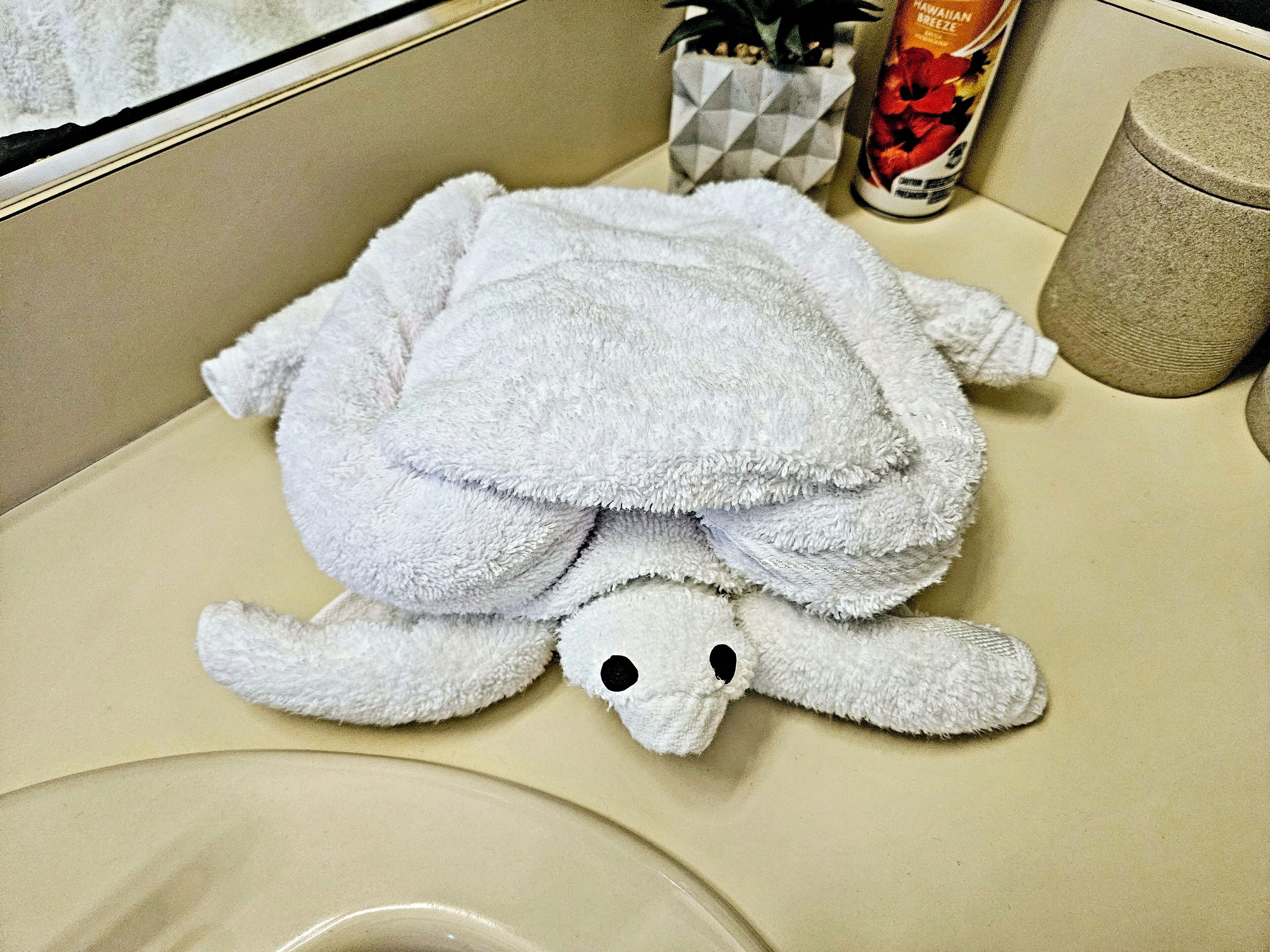 Un bagno con un asciugamano a forma di tartaruga posato sul lavandino.