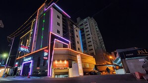 A building with neon signage, including a motel and parking area. - Ulsan Palace (Ulsan)