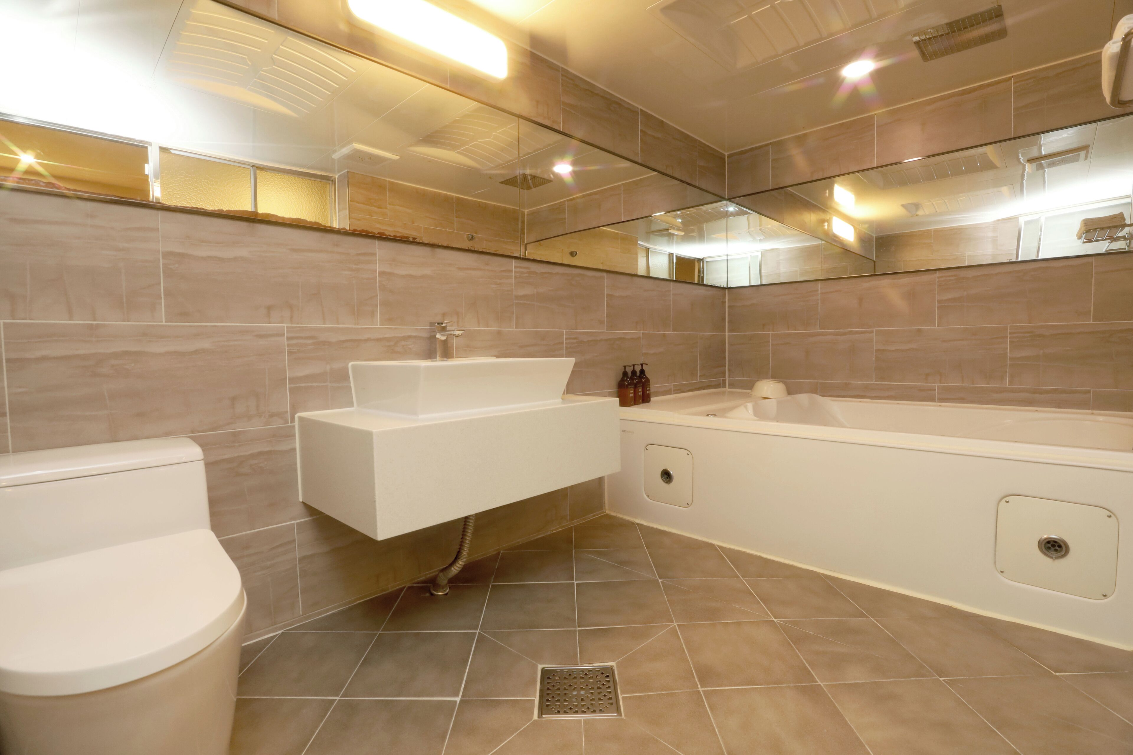 A modern bathroom with a white sink, toilet, and bathtub.