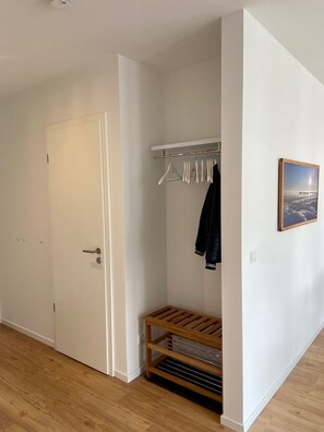 A hallway with a coat rack, a bench, and a door. - 2915 Wohnung 5 - 2915 - Strandwiese 1 - Wohnung 5 (Dahme)
