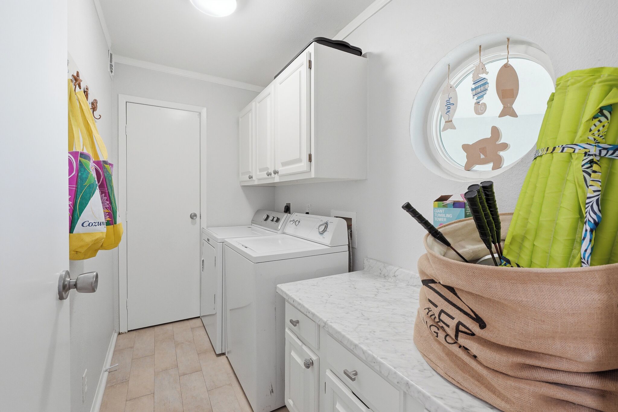 A laundry room with a washing machine, a drying machine, and a mirror with decorative cutouts.