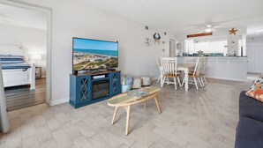 A modern living room with a TV, a dining area, and a kitchen. - La Mirage Condo 218 Beachfront Resort Condominiums with Private Boardwalk (Port Aransas)