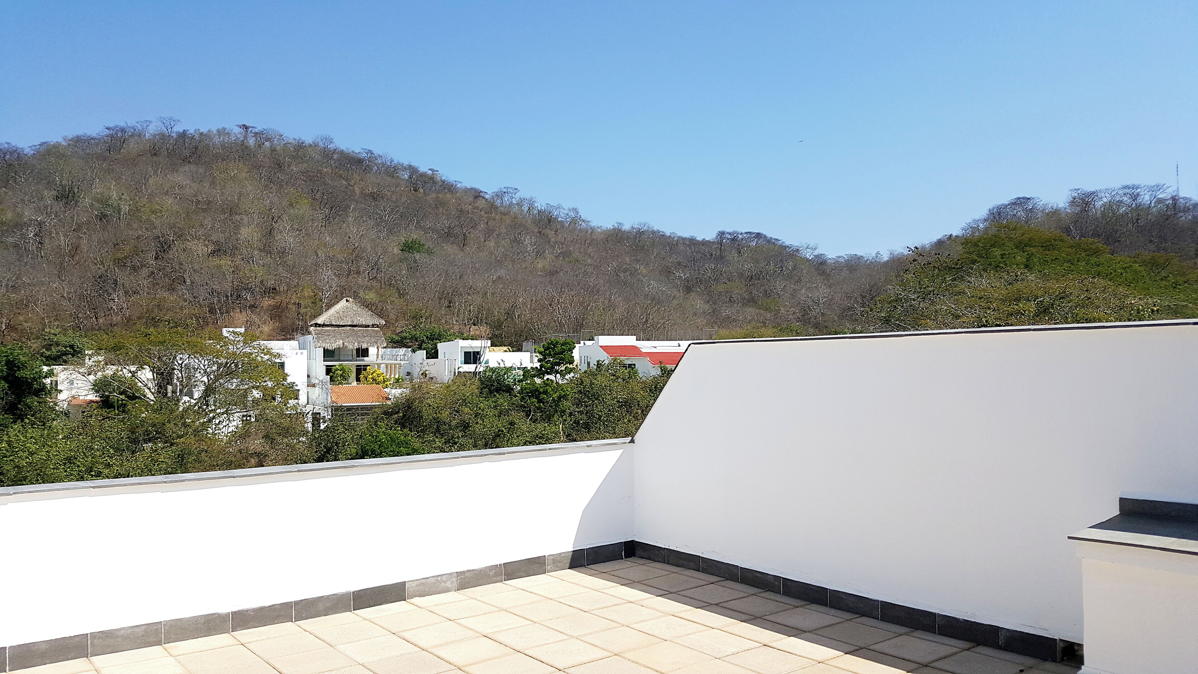 Una terrazza sul tetto con vista su una collina ed edifici.