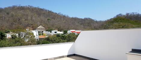 Una terrazza sul tetto con vista su una collina ed edifici.