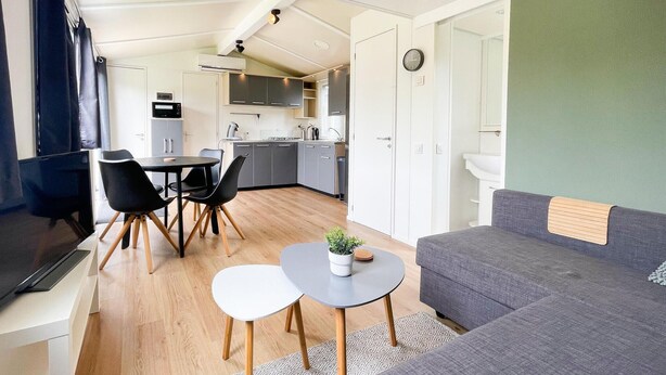 A compact living space with a kitchenette, a dining area with chairs, a sofa, and a TV. - Gorgeous home in Tzummarum with WiFi (Tzummarum)