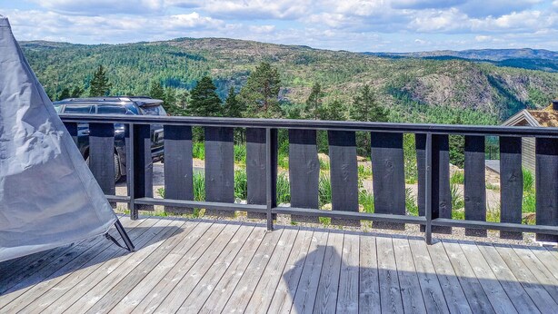 Een houten terras met uitzicht op een bergachtig landschap.