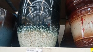 A shelf with ceramic pots and a price tag. - Loft Shandde Park (Quito)