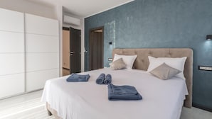 Une chambre moderne avec un grand lit, une armoire et une porte donnant sur une autre pièce.