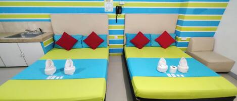 A hotel room with two beds, a sink, a telephone, and a striped wall.