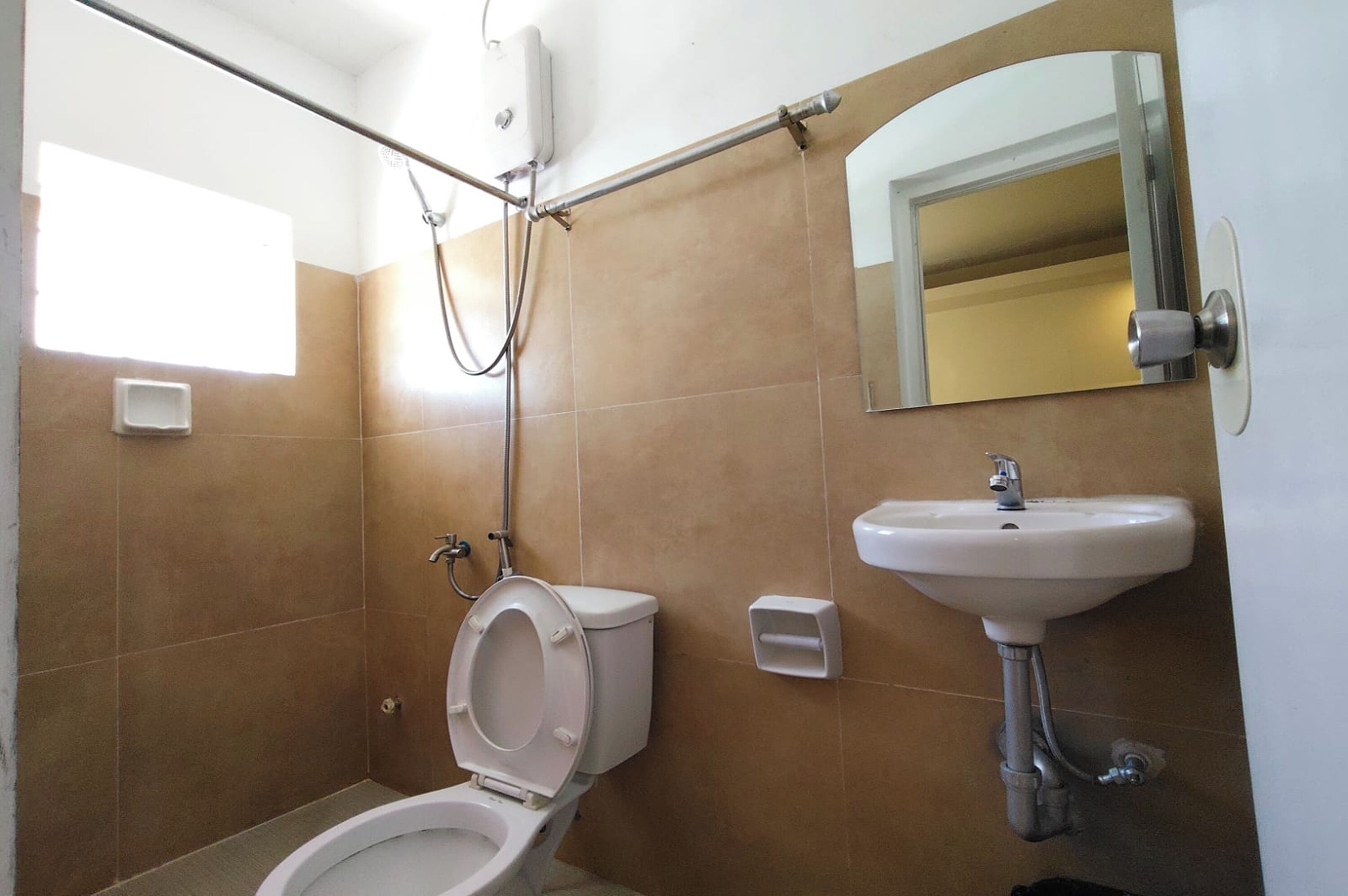 A bathroom with a toilet, a sink, a shower, and a mirror.