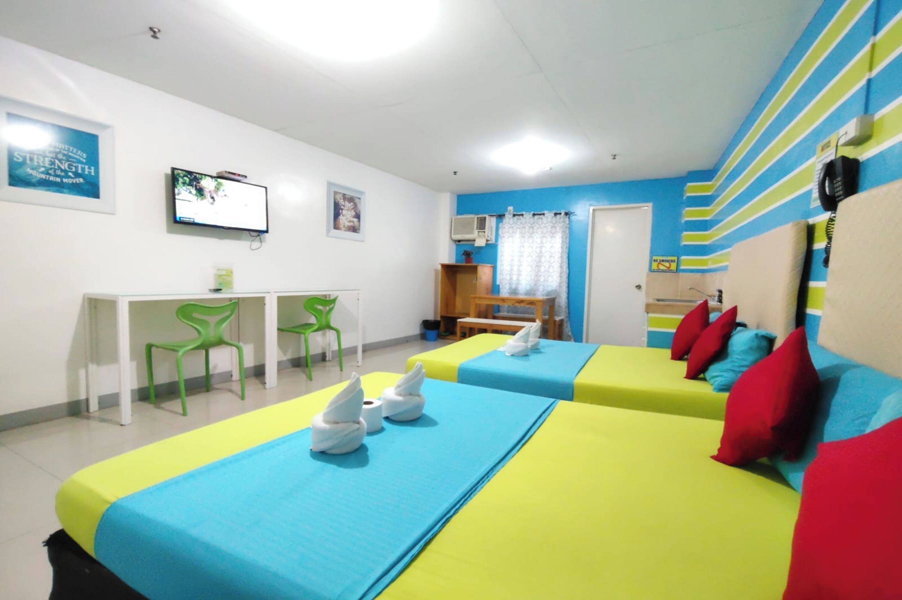 A room with two beds, a desk, and a chair.
