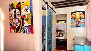 Una stanza con un letto, un armadio blu e due quadri alle pareti.