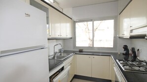 A compact kitchen with white cabinets, a stainless steel sink, a dishwasher, and a stove. - House for summer rental close to the beach.HUTG-071958 (l'Escala)