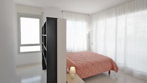 A bedroom with a bed, a nightstand, a lamp, a window, and a door. - House for summer rental close to the beach.HUTG-071958 (l'Escala)