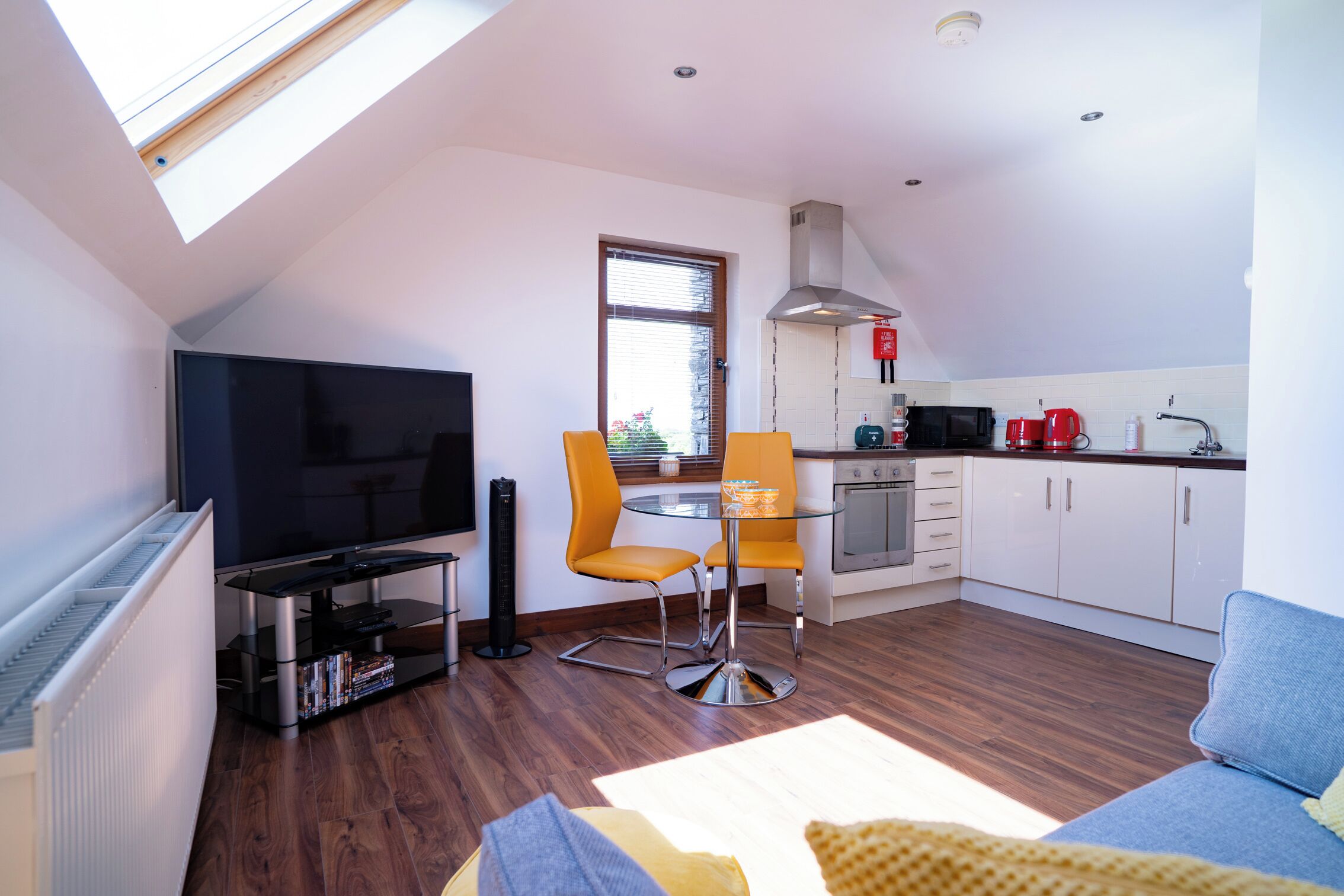 Eine moderne Wohnung mit Wohnzimmer, Essbereich, Küche und Fernseher.