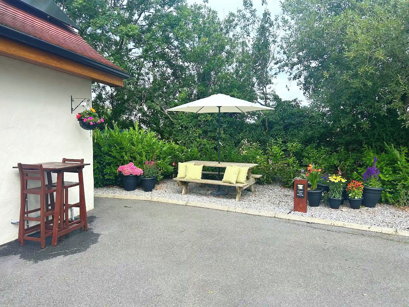A patio area with a table and chairs, a bench, and potted plants.