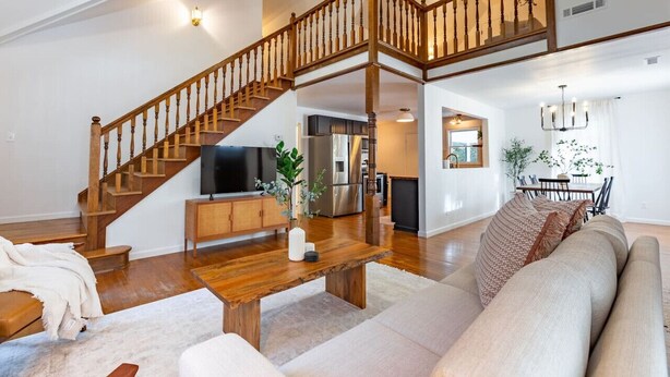 A spacious living area with a wooden staircase, a kitchen, and a dining area. - Our Peaceful Haven - 6 minutes to Trilith Studios (Fayetteville)